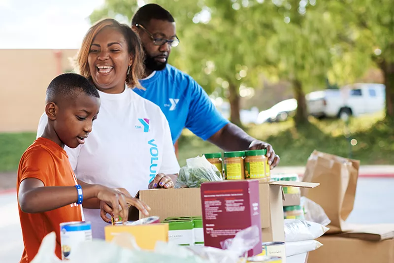 Family helping distribute food at the YMCA