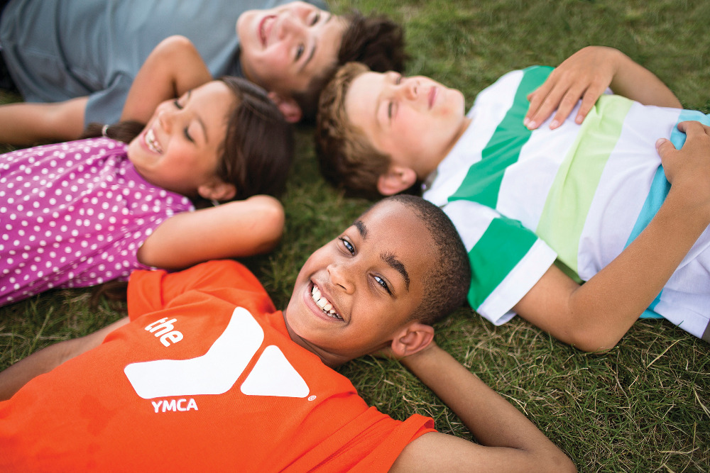 Kids at Summer Camp laying on ground in circle