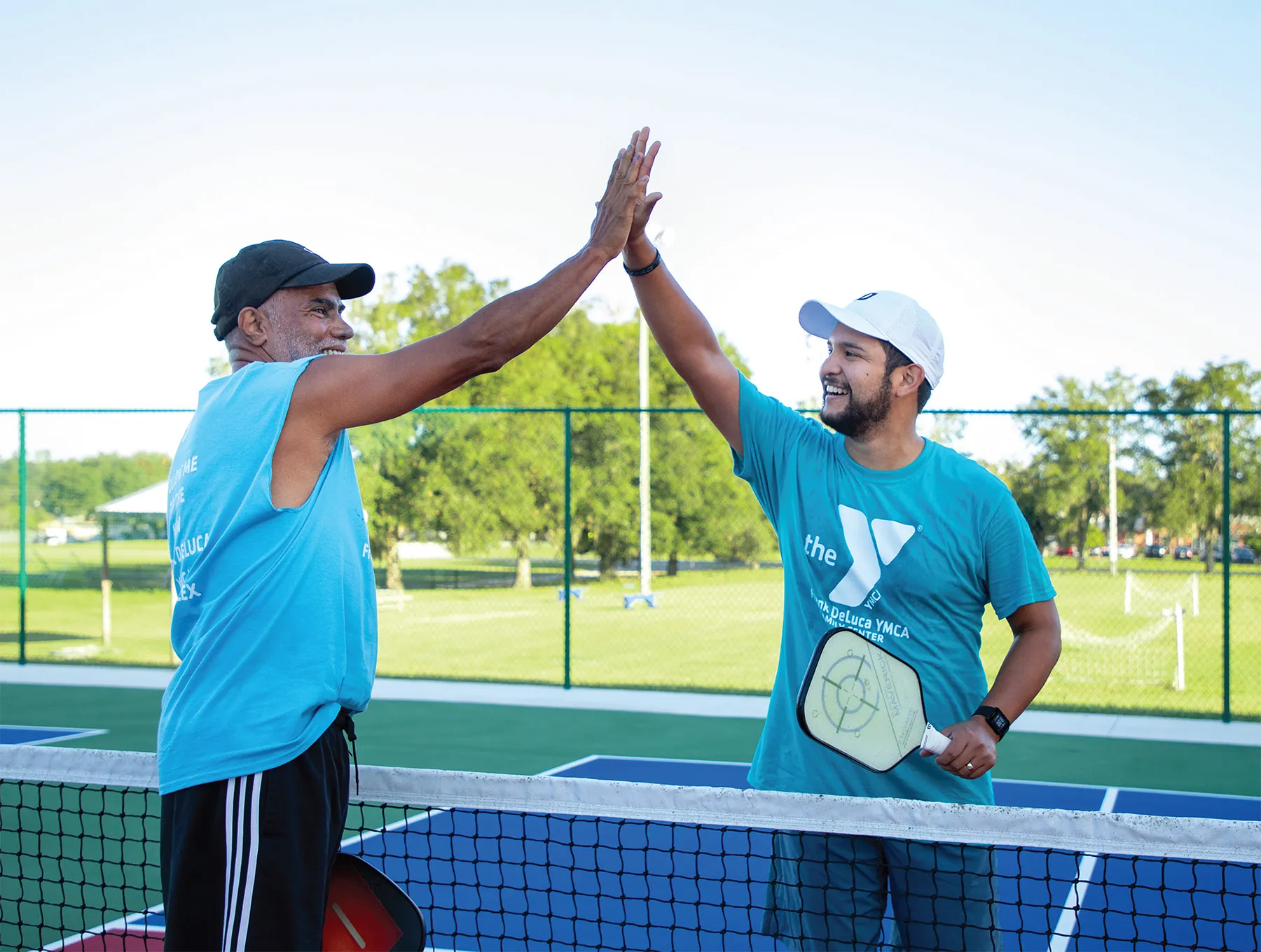 men giving high fives while playing pickleball