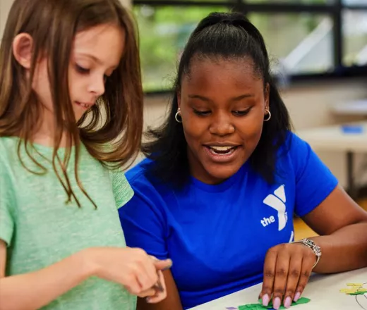 Young Woman helping teach a young girl at the YMCA